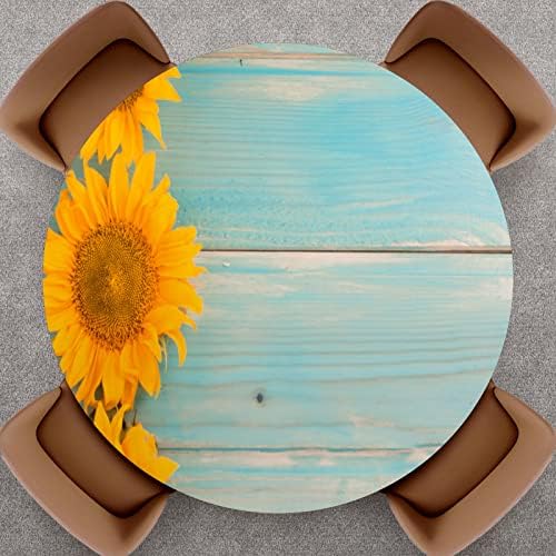 Poklopac okruglog stola Suncokreti na plavoj drvenoj ploči opremljeni elastičnim obrubljenim poliesterskim stolnjakom uklapa se u stolove